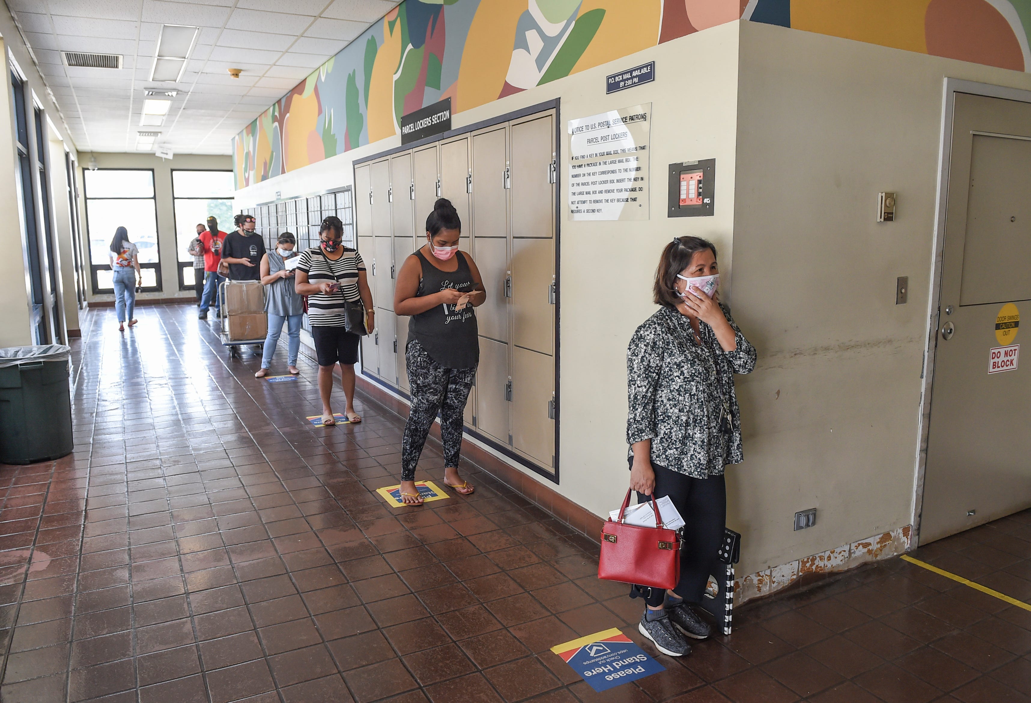 Customers line up while following social distancing guidelines at the U.S. Postal Service's Tamuning location on Sept. 25, 2020.