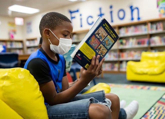 Astoria Park Elementary School second grader Dah'Kai Crawford, 7, reads a library book Friday, Sept. 25, 2020.