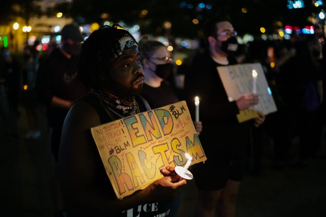 Lee Laney, of Columbus, listens during a candlelight vigil for Breonna Taylor on Friday, Sept. 25, 2020 at the Ohio Statehouse in Columbus, Ohio.