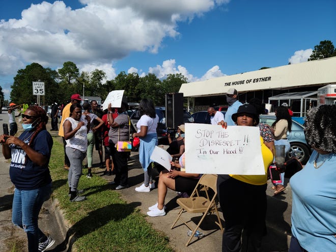 The community gathers outside Brothers Store, located across the street from them at 301 E. Highland Ave., Saturday, Sept. 26, to protest against what they say was an attack on a Black woman by the store's clerks Friday night. [Brandon Davis/Kinston Free Press]