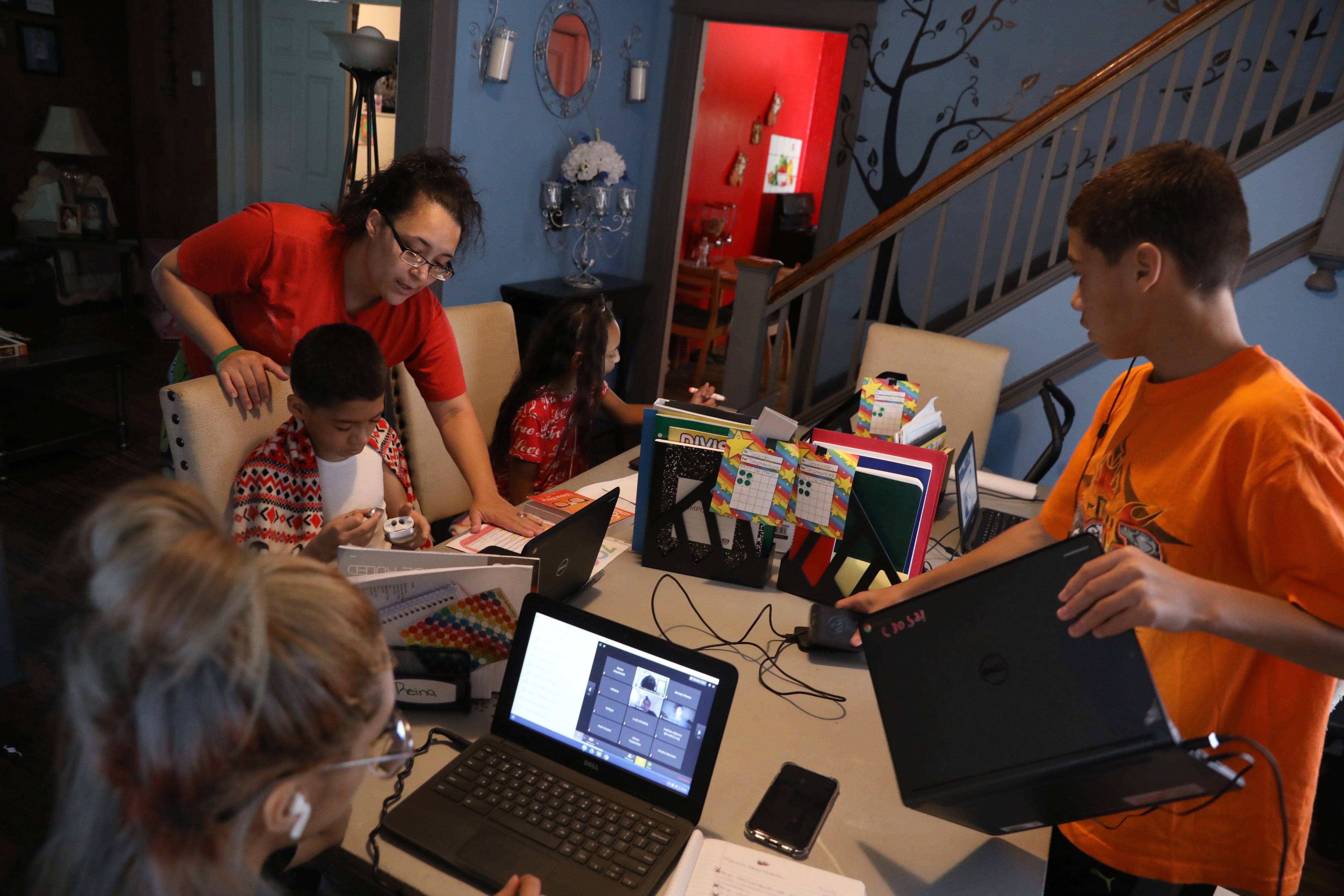 Mother Zumarie Sepulveda checks in on the progress of son Jacob, a fifth grader, and all her kids as they sit together in the living room for online learning from their schools at their home in Rochester Friday, Sept. 25, 2020. 