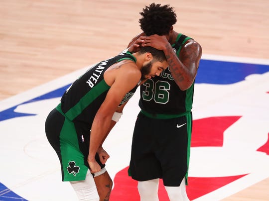 Boston Celtics guard Marcus Smart speaks with forward Jayson Tatum during the second half of Game 5 against the Miami Heat.