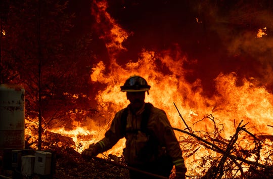 A Marin County firefighter helps to build containment lines during the Glass fire in St. Helena, Calif. on Sept. 27, 2020.