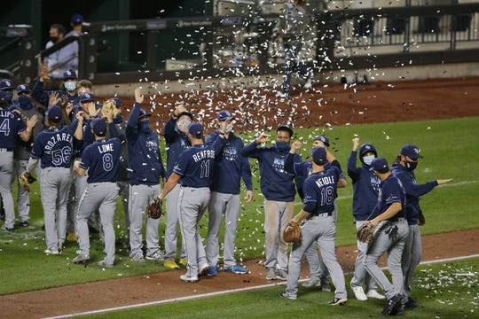 The Tampa Bay Rays celebrate clinching the American League East division title with confetti cannons after defeating the New York Mets at Citi Field.