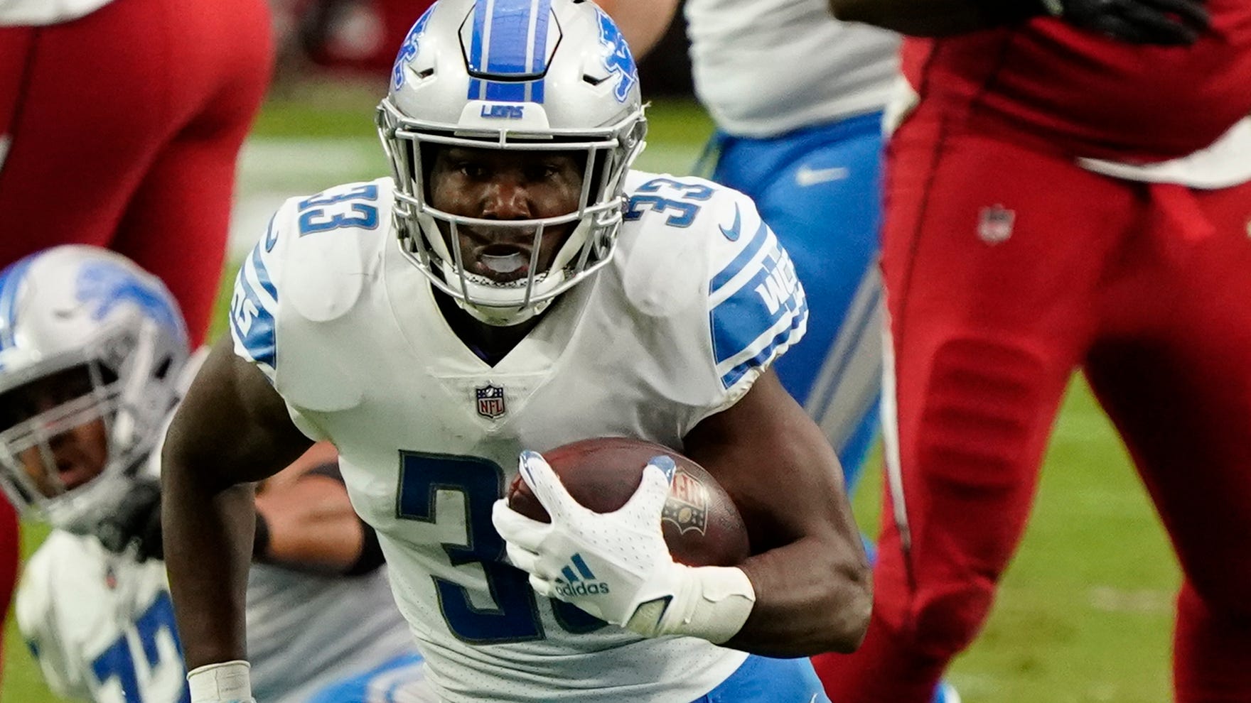 Running back Kerryon Johnson (33) remains the starter in the Lions' backfield that also features D'Andre Swift and Adrian Peterson.