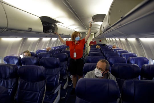 A Southwest Airlines flight attendant prepares a plane bound for Orlando, Fla., for takeoff at Kansas City International airport in Kansas City, Mo. About 40,000 workers in the airline industry are facing layoffs on Thursday, Oct. 1, unless Congress comes up with another aid package.