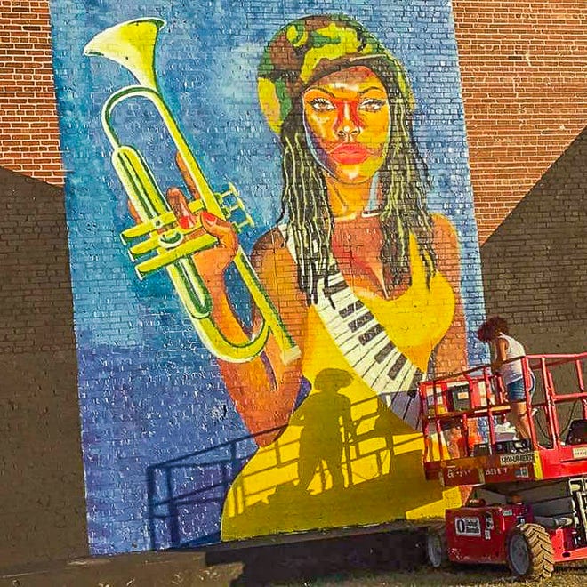 Jamie Bonfiglio works on her mural in Birmingham, Al.