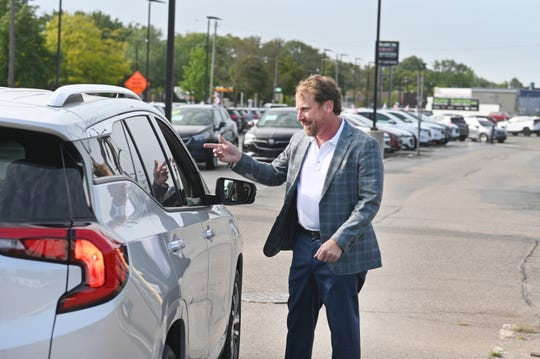 Jeff Laethem, of Ray Laethem Buick GMC, speaks with customers as their car lot inventory is at low levels due to the coronavirus pandemic.