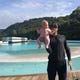 American professional surfer Sebastian Zietz of Hawaii holds daughter, Milly, in front of Wavegarden's prototype of its artificial wave technology in Northern Spain in October 2019.