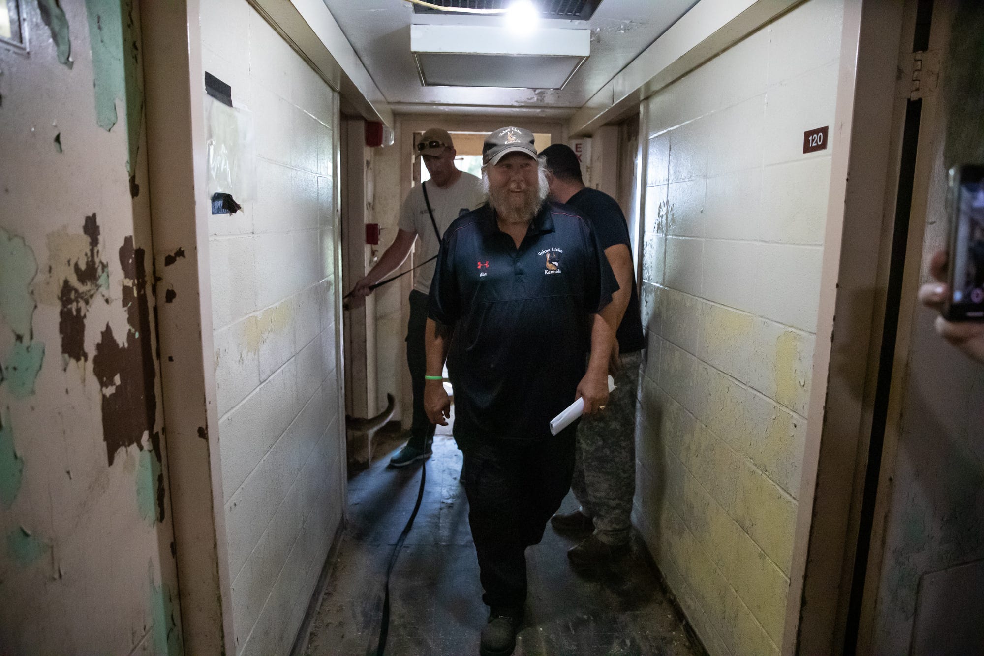 Kenneth Licklider, owner of Vohne Liche Kennels, walks through a hallway in one of the many training buildings at his Indiana facility in September. Licklider, who founded the company in 1993 after retiring from the military, has been training canines for more than 40 years.