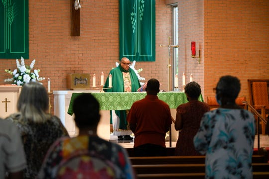 Parishioners stand in Our Lady of Grace Catholic Church in Reserve, LA., during a sermon by the Rev. Fr. Christopher Chike Amadi. Black Americans have faced increased incidents of COVID-19-related illness and death during the pandemic.