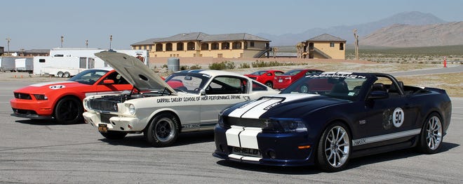 A 2012 Ford Mustang Boss 302, a 1965 Shelby GT350, and a 2013 Shelby GT350 convertible wait their turn on the track during the 6th annual Shelby Bash at Spring Mountain Motorsports Ranch in Pahrump, Nevada.