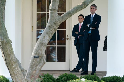 Michael Haidet, in charge of presidential scheduling and advance, right, Oval Office special assistant Austin Ferrer, look out from outside the Oval Office as President Donald Trump departs the White House, Sept. 30, 2020, in Washington, for the short trip to Andrews Air Force Base en route to Minnesota. 