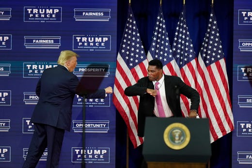 President Donald Trump elbow bumbs with Herschel Walker during a campaign rally, Sept. 25, 2020, in Atlanta.