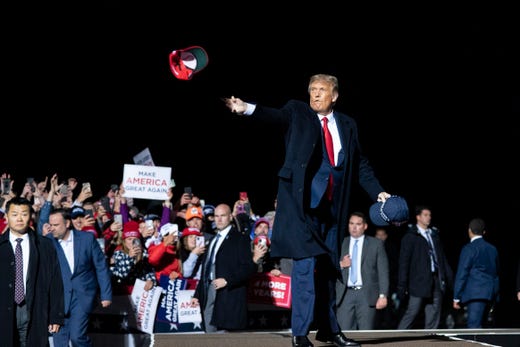 President Donald Trump tosses a hat to supporters as he arrives to speak at a campaign rally at Duluth International Airport, Sept. 30, 2020, in Duluth, Minn.