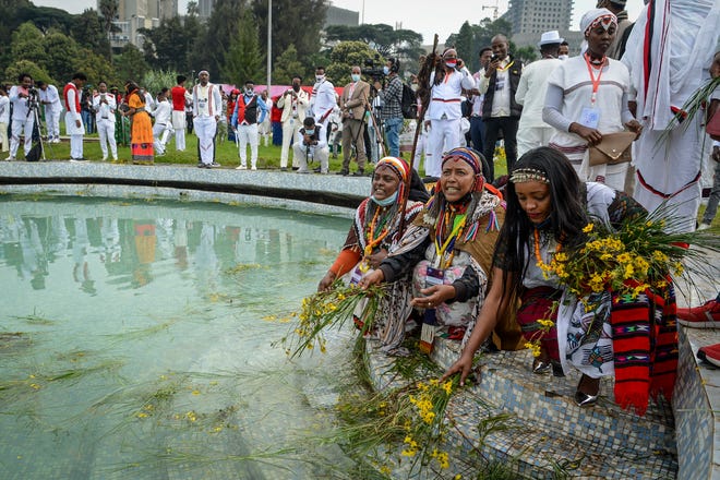 Ethiopians celebrate the festival of Irreecha by throwing grass and flowers into a pool of water to thank God for the blessings of the past year and to wish prosperity for the coming year, in the capital Addis Ababa, Ethiopia, on  Saturday. Ethiopia's largest ethnic group, the Oromo, on Saturday celebrated the annual Thanksgiving festival of Irreecha amid tight security and a significantly smaller crowd due to political tensions and the COVID-19 pandemic.