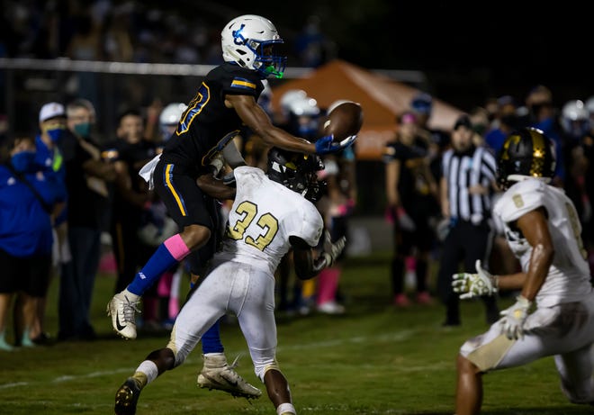 John Carroll Catholic High School wide receiver Prince Strachan attempts to jump over a Treasure Coast High School defender to catch a pass on October 2, 2020 in Fort Pierce.