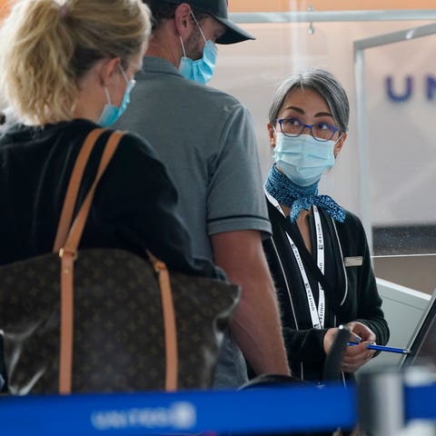 Travellers check in at a United Airlines kiosk wit