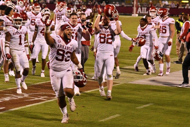 Arkansas players celebrate after beating Mississippi State, snapping the Razorbacks' 20-game SEC losing streak.