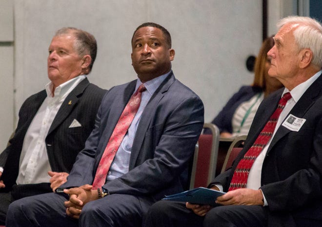 William Latson is flanked by Superintendent Art Johnson (left) and his attorney, Thomas Elfers, while waiting for a vote on his termination as Spanish River principal on Oct. 30, 2019.