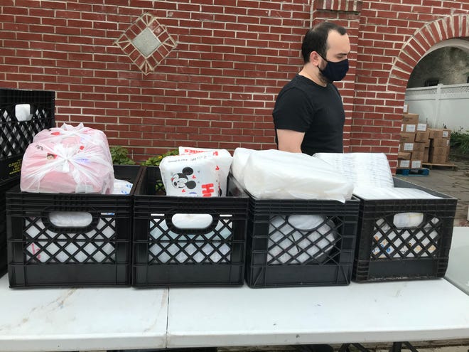 Mighty Writers intern AJ Maiorana brings out crates filled with diapers for families in need.