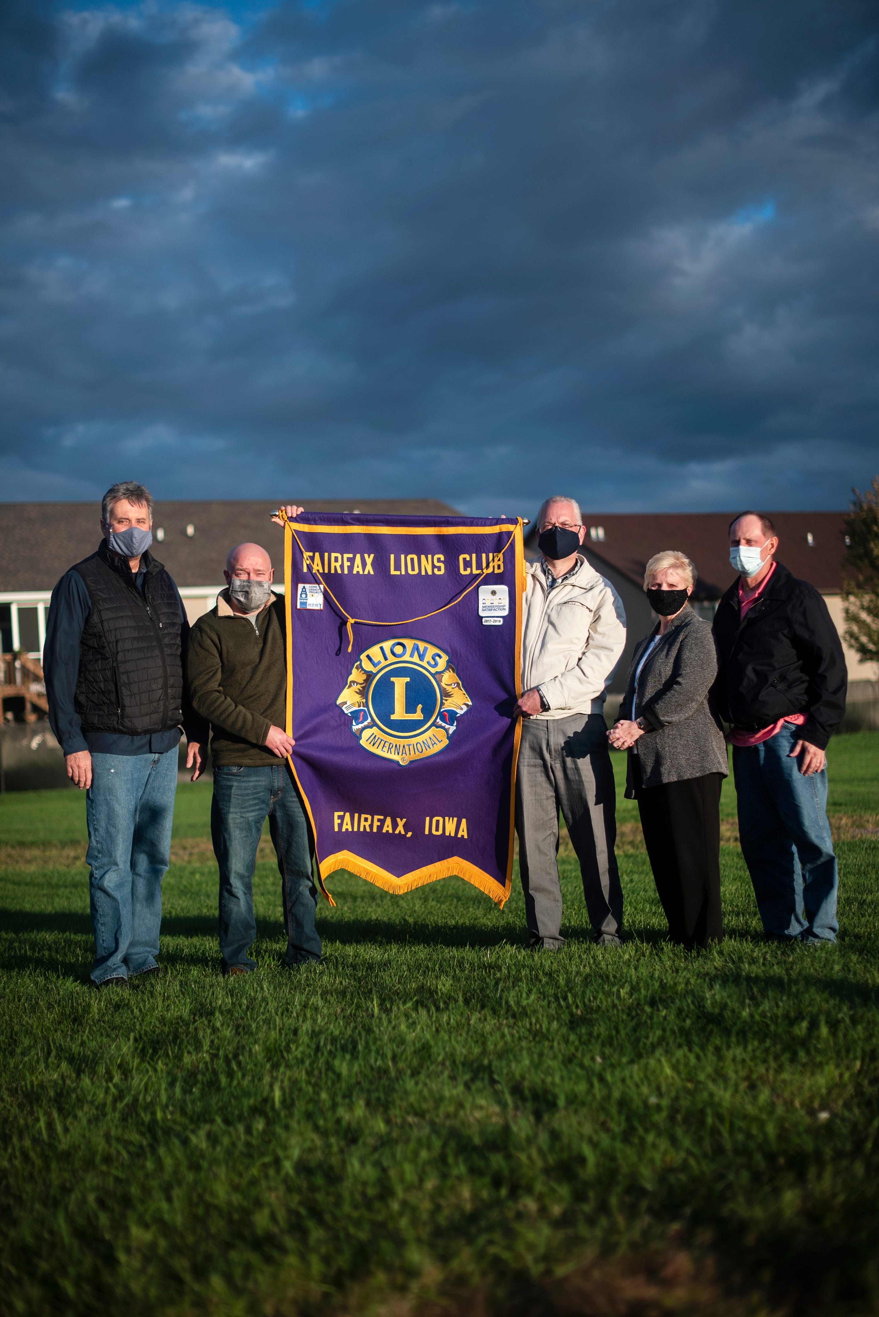 Fairfax Lions Club members Ed Faber, Dusty Weeks, Dean Schrader, Deb Mallie, and Paul Mallie pose for a portrait to honor their friend Kathy Everett, who died of COVID-19.