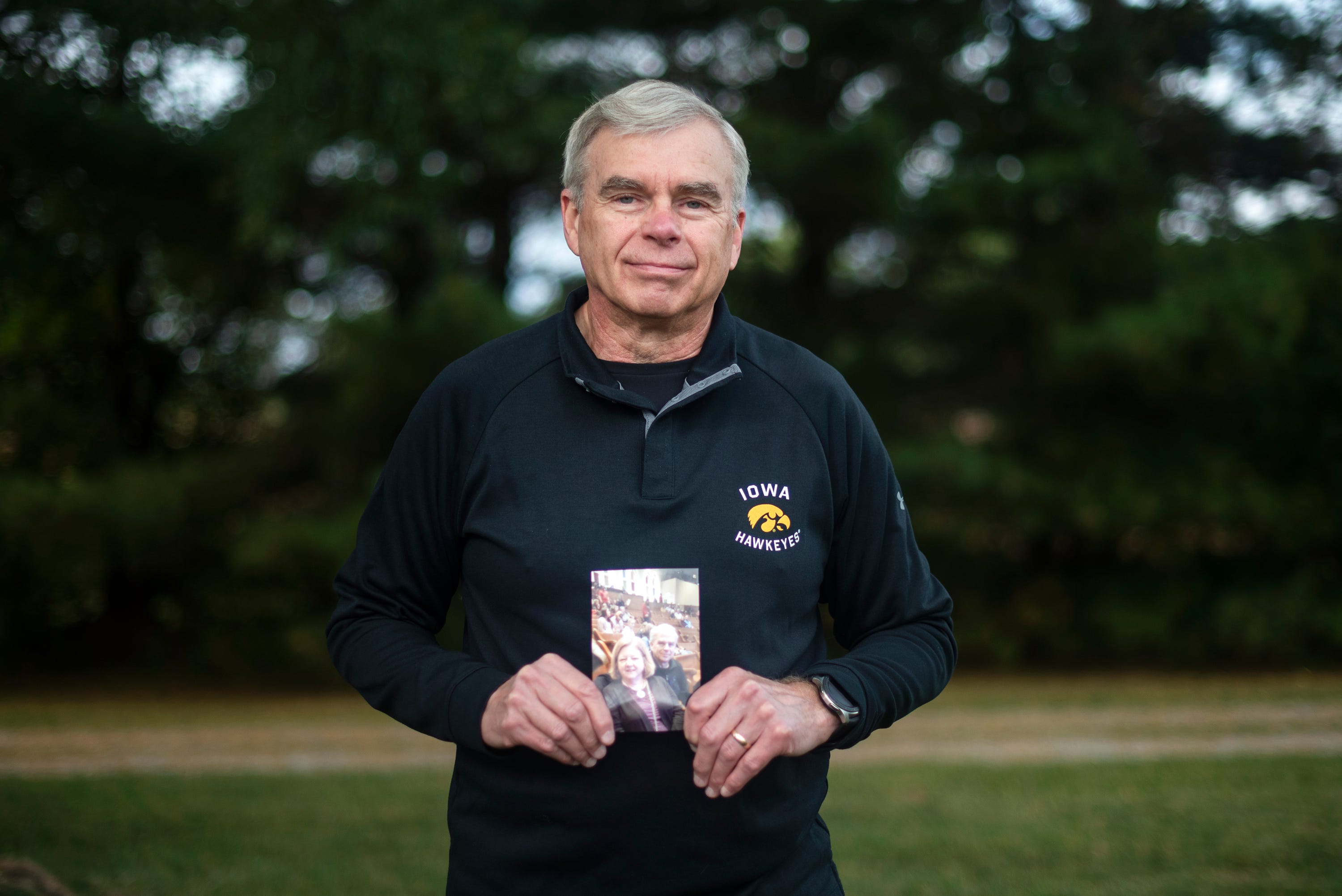 Ken Thiry holds a photo of his late wife, Regina, who died of COVID-19.