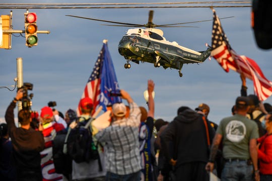 Supporters of President Donald Trump look on as he departs from Walter Reed National Military Medical Center aboard Marine One on Oct 5, 2020.