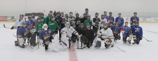 The players pose for a group picture after the Crookston Blue Line Club's Peewee 3v3 Stanley Cup tournament.