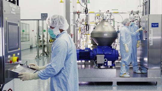 In this undated image from video provided by Regeneron Pharmaceuticals on Friday, Oct. 2, 2020, scientists work with a bioreactor at a company facility in New York state, for efforts on an experimental coronavirus antibody drug. Antibodies are proteins the body makes when an infection occurs; they attach to a virus and help the immune system eliminate it.
