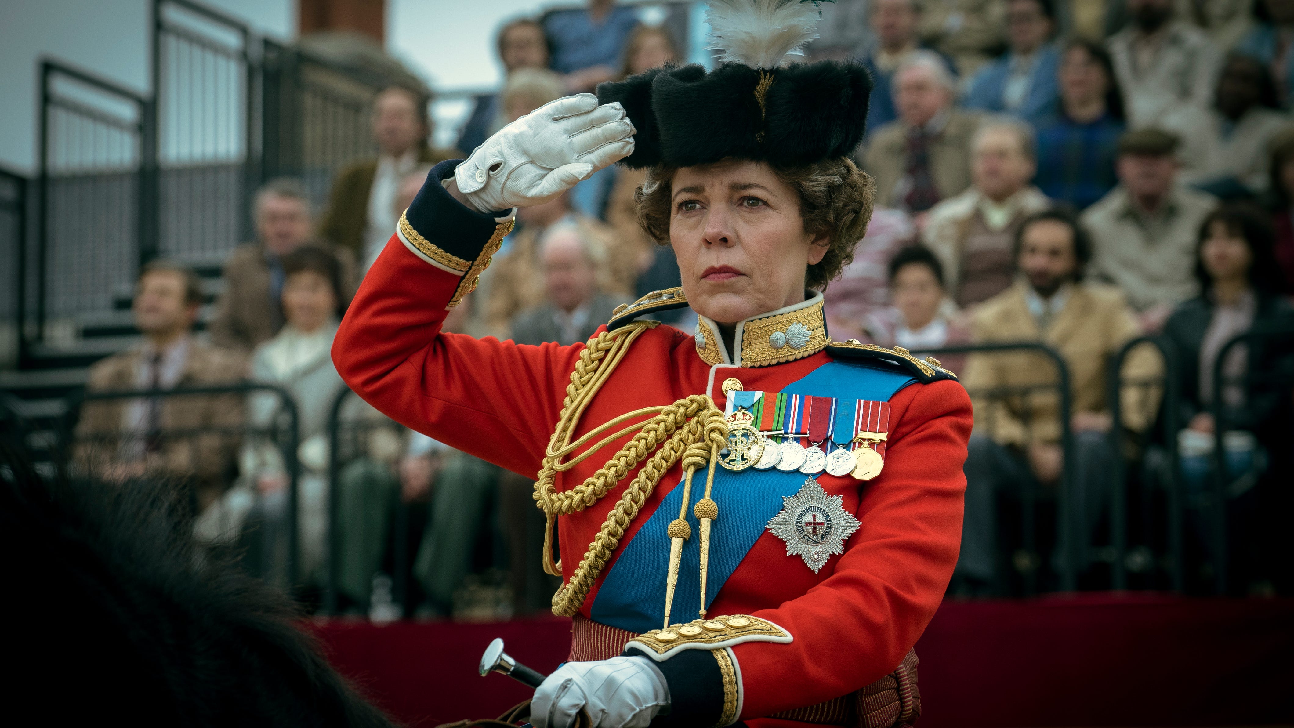 Olivia Colman raises a salute as Queen Elizabeth II in "The Crown."