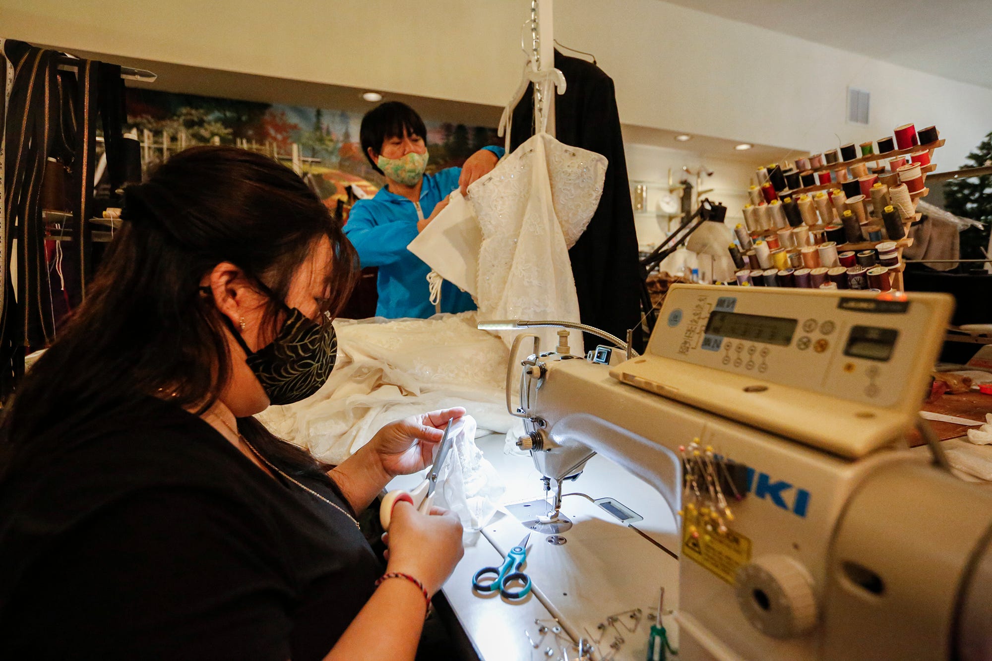 Bao and Soua Xiong of S&B Alterations work on dresses  at their shop at 47 S. Main Street in Fond du Lac. The business has been inundated with a backlog of wedding dress alterations that were previously on hold because of COVID-19 restrictions.