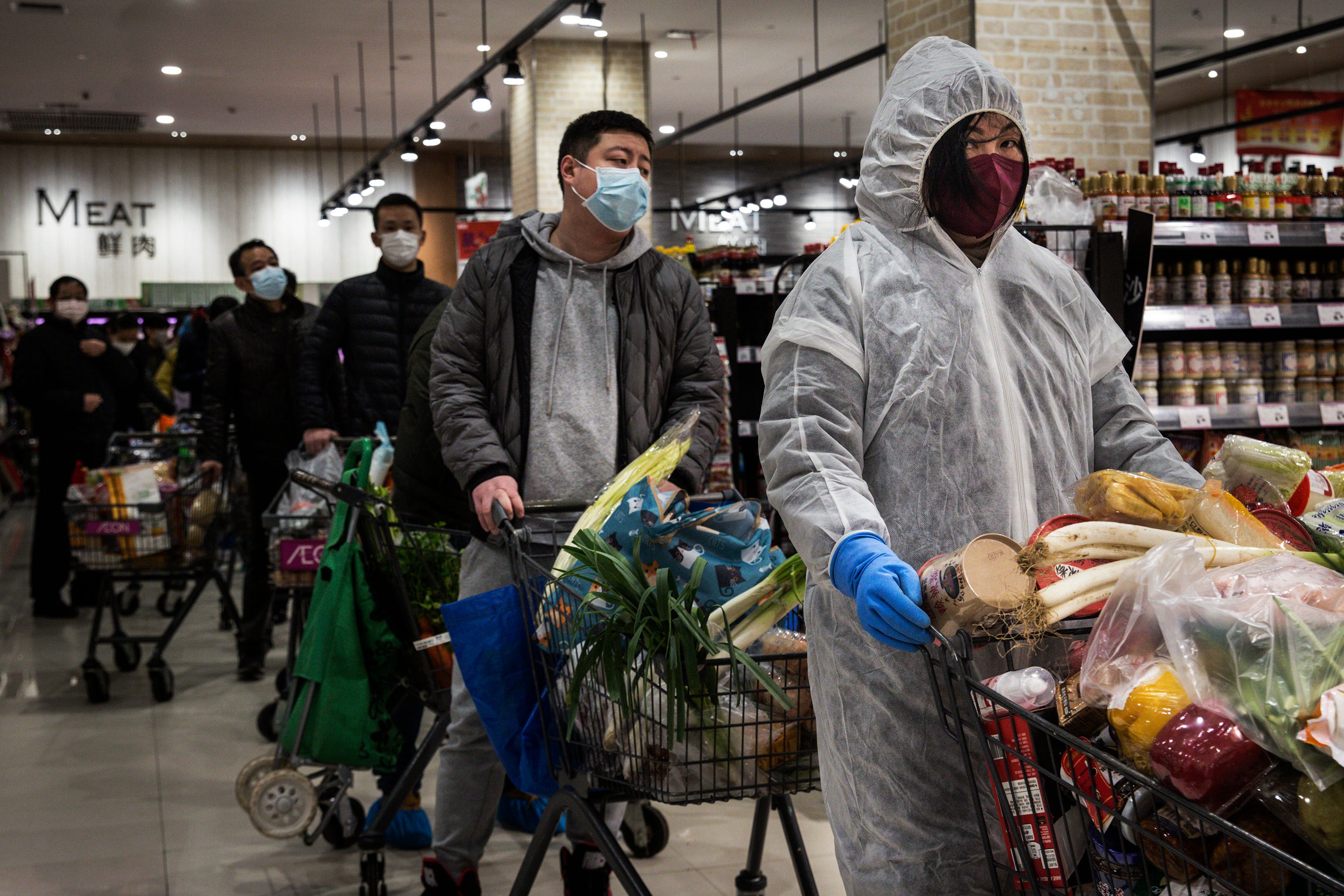 People wear protective masks as they line up in a supermarket on Feb. 12 in Wuhan, China.