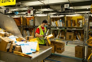 Sean Barry, an Amazon associate, scans various packages and puts them in the coordinated delivery bin at a Goodyear Amazon delivery station.