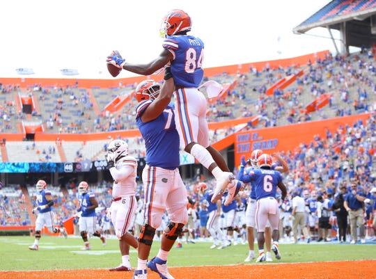 Florida tight end Kyle Pitts (84) celebrates a touchdown catch a teammate during a game against South Carolina at Ben Hill Griffin Stadium.