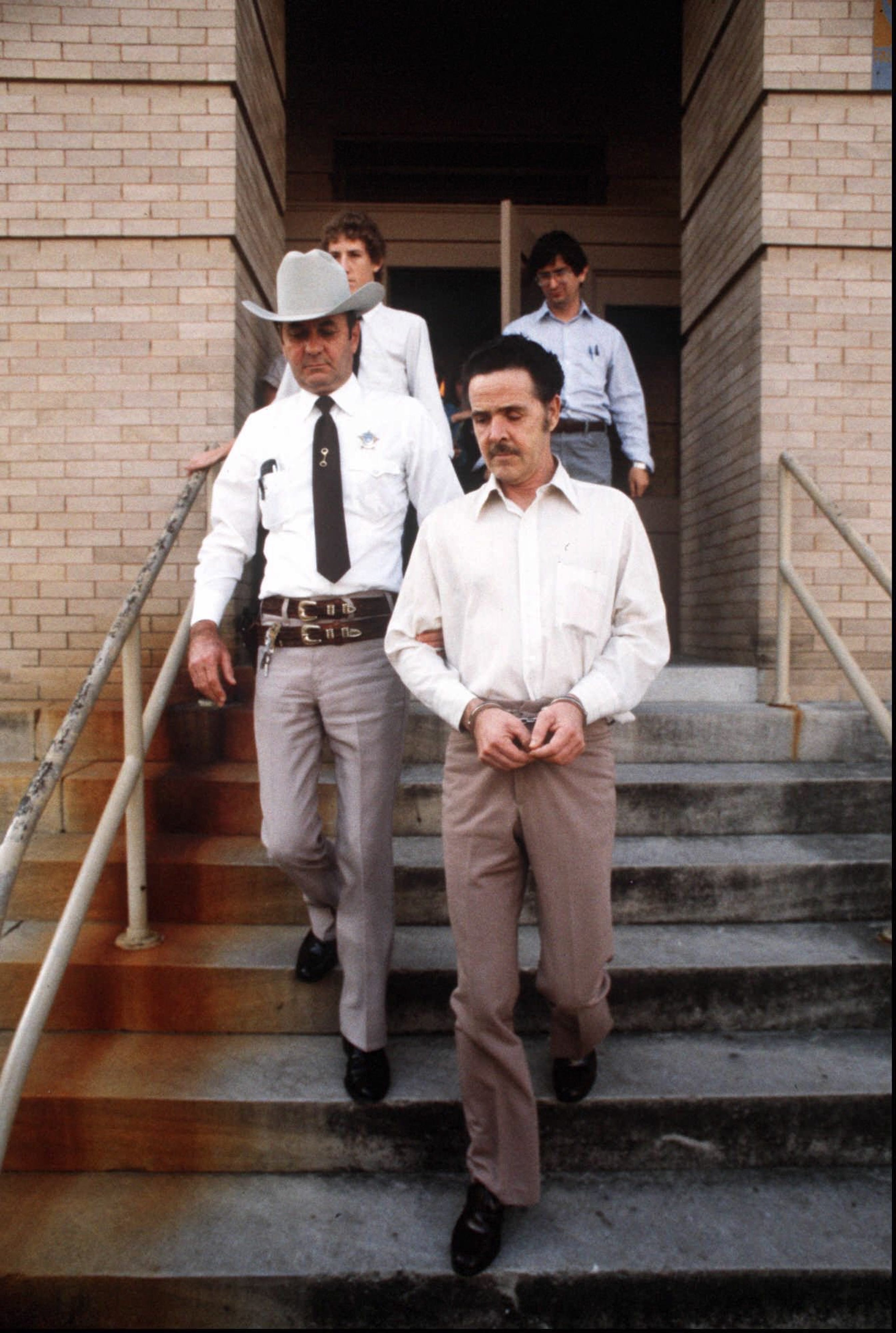 Mass killer Henry Lee Lucas is escorted by Williamson County Sheriff Jim Boutwell from the Williamson County Courthouse in 1983.