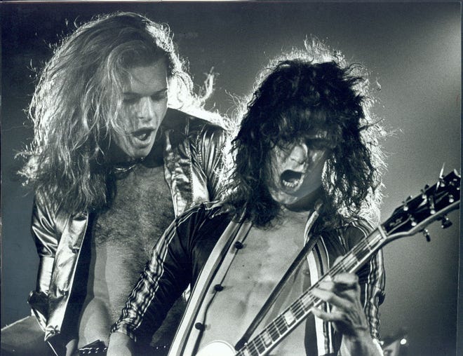 David Lee Roth and Eddie Van Halen of rock band Van Halen perform in July 1978 at the Long Beach Arena. Eddie Van Halen has died at age 65 of cancer.