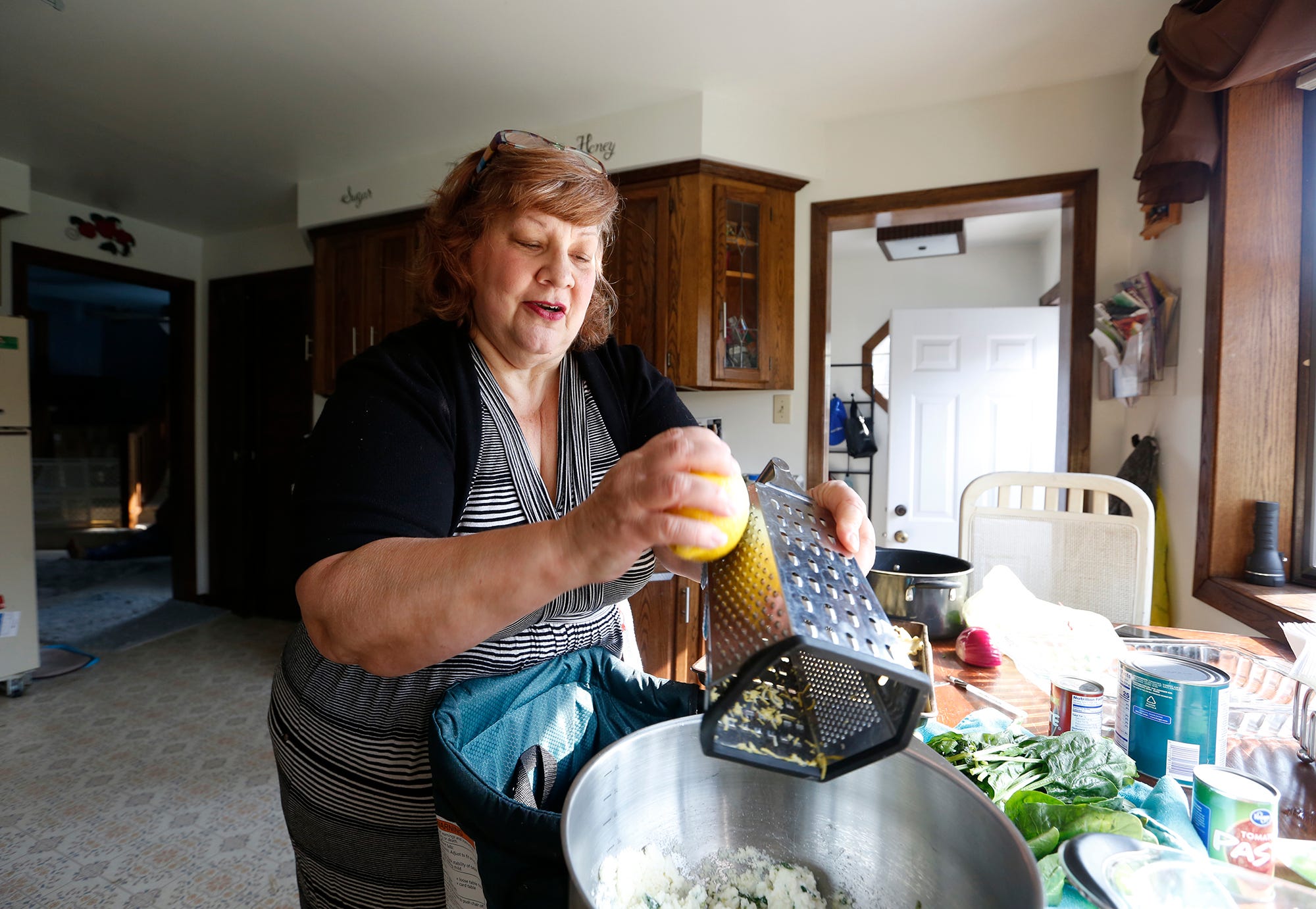 Cindy Martinez of Fond du Lac cooks lunch for her daughter and granddaughter in her kitchen. Martinez was laid off from her job this spring when COVID-19 struck. She finds fulfillment in mentoring young women who have experienced emotional trauma.