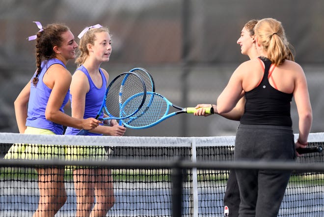 Jackson's Paige Reese and Madison Altman (left) celebrate a win against Hoover's Angelina Koinoglou and Izzy Warburton in a girls tennis Division I sectional semifinal at Jackson North Park Saturday, Oct. 10, 2020.