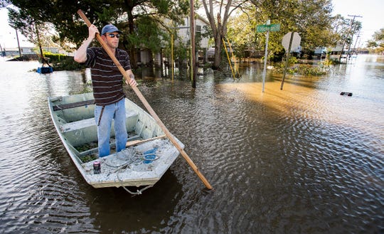 Len Moneaux poles his boat along a flooded street as he checks on neighbors in Delcambre, Louisiana, on Saturday morning Oct. 10, 2020, after Hurricane Delta hit the Louisiana Coast overnight.