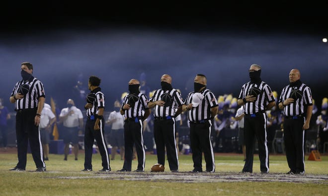 Officials listen to the national anthem before a game against Mesquite at Sunrise Mountain High School in Peoria, Arizona, on Oct. 9, 2020.
