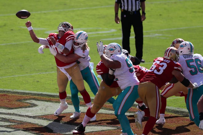 San Francisco 49ers quarterback Jimmy Garoppolo, left, fumbles the ball as he is hit by Miami Dolphins outside linebacker Andrew Van Ginkel during the first half of an NFL football game in Santa Clara, Calif., Sunday, Oct. 11, 2020. The 49ers recovered the ball.