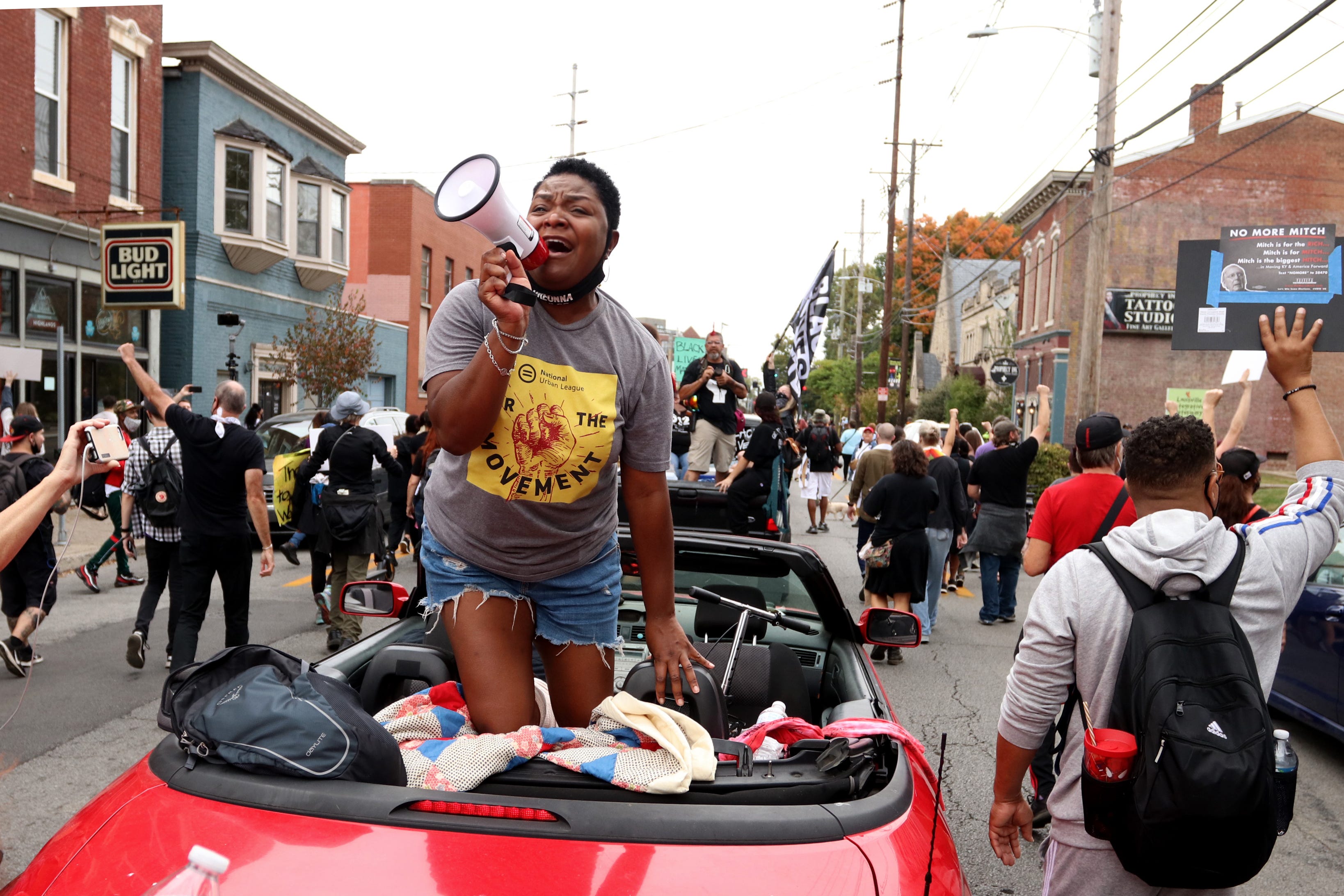 Sadiqa Reynolds, president and CEO of the Louisville Urban League, leads chants from a convertible during a march for Breonna Taylor. Oct. 10, 2020