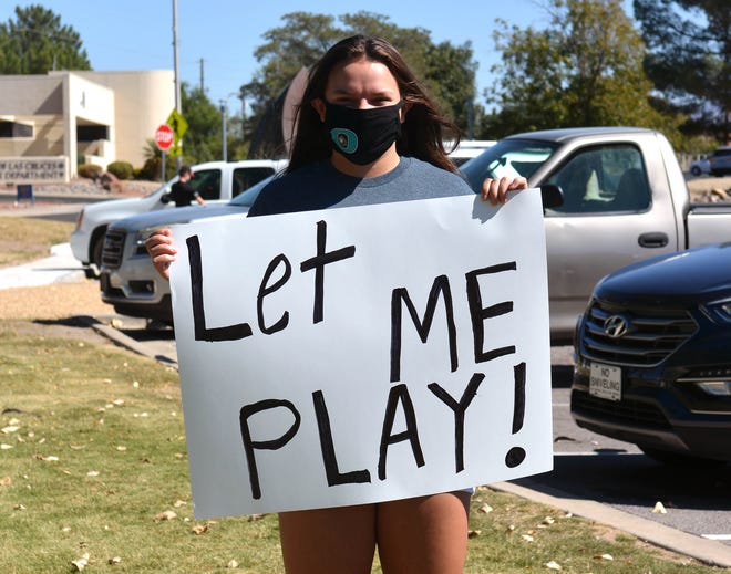 Helena Strawbridge, una estudiante de secundaria en Onat, sostiene un cartel frente a la Biblioteca Branigan el domingo 11 de octubre de 2020, para protestar por el aplazamiento de los deportes de otoño en Nuevo México.