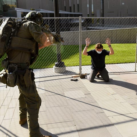 A man is pictured being taken into custody after f