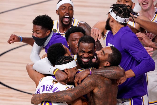 Los Angeles Lakers' LeBron James (23) celebrates with his teammates after the Lakers defeated the Miami Heat 106-93 in Game 6 of basketball's NBA Finals Sunday, Oct. 11, 2020, in Lake Buena Vista, Fla. (AP Photo/Mark J. Terrill)