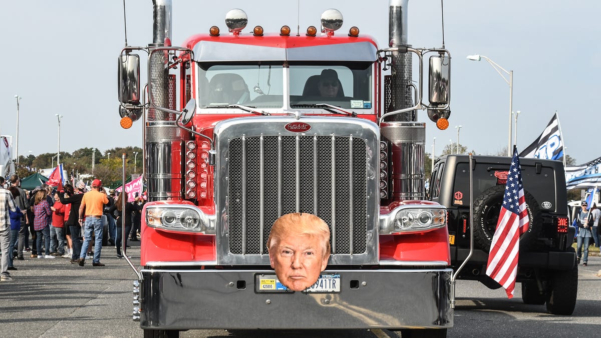 A truck with a picture of Donald Trump drives through a pro-Trump rally on October 11, 2020 in Ronkonkoma, New York. With President Trump testing positive for the coronavirus and less than one month left until the U.S. Presidential election, Trump supporters have been organizing weekly rallies.