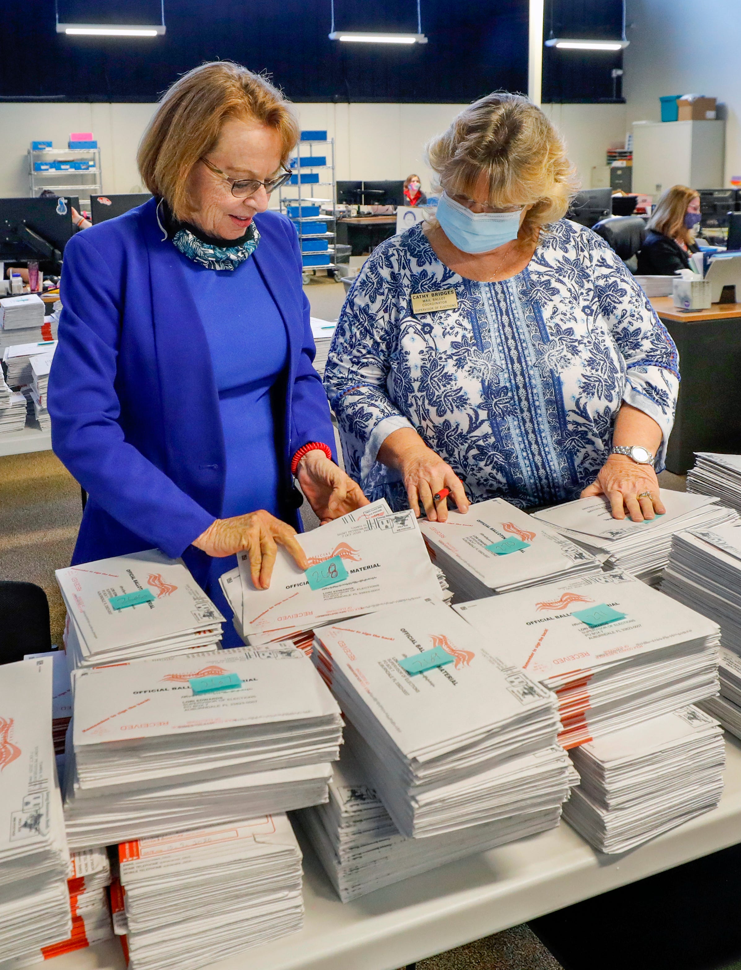 Supervisor of Elections Lori Edwards and Cathy Bridges, mail ballot coordinator, look over some of the mail-in ballots that have already arrived at the Polk County Supervisor of Elections facility in Winter Haven.