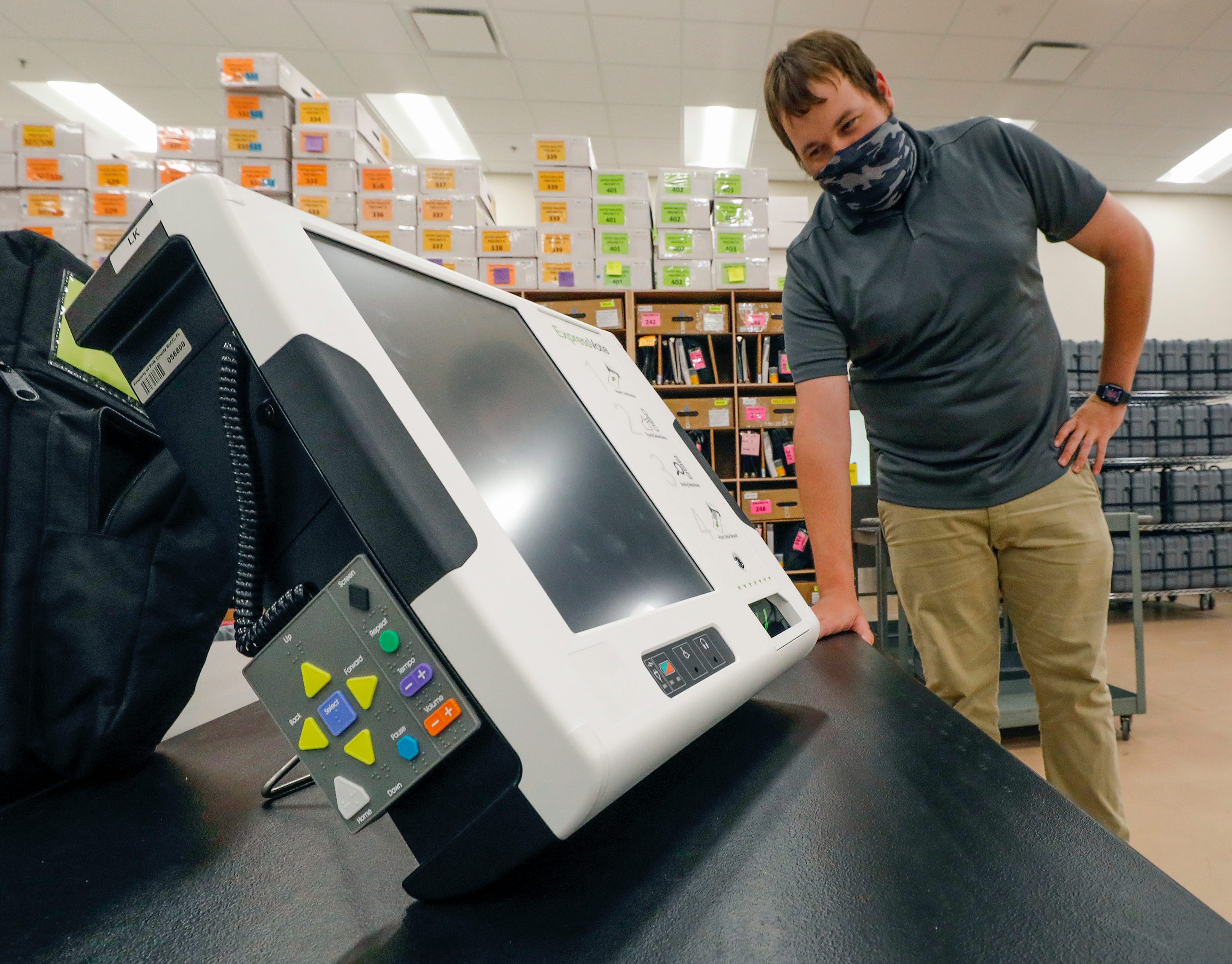 Curtis Hatfield, operations manager, with the express vote machine used to assist the visually impaired and voters with disabilities at the Polk County Supervisor of Elections facility in Winter Haven.