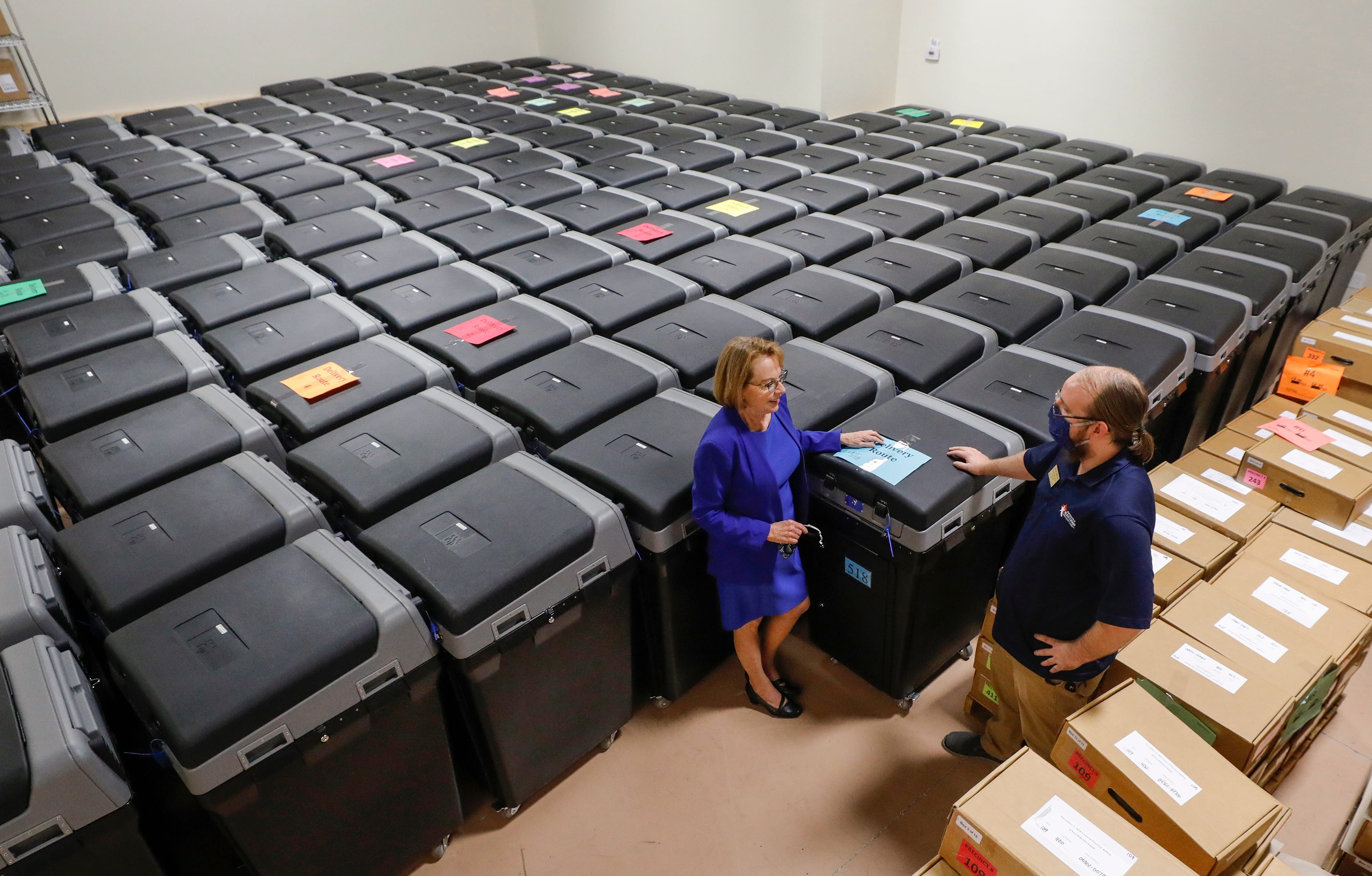 Supervisor of Elections Lori Edwards talks with Zack Bryan, operations support assistant, as they stand with some of the DS200 ballot tabulators ready to be distributed to the polling places across Polk County for the Nov. 3 general election.